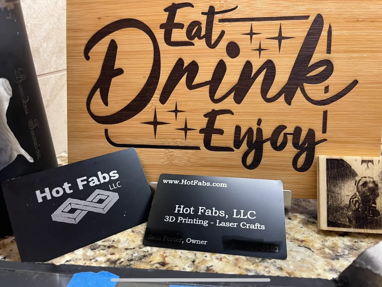 Laser engraved Hot Fabs business cards and a wooden Eat Drink Enjoy sign